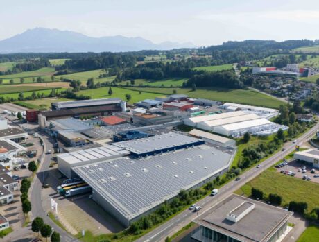 Luftaufnahme der Bachmann Forming AG. Weitläufiger Gebäudekomplex, mit Solaranlagen auf den Dächern.
